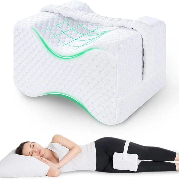 Coussin genoux ergonomique blanc avec sangle ; femme dormant sur le côté avec le coussin placé entre les jambes.